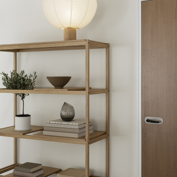 Cozy living space featuring a wooden shelf, decorative items, and a warm lamp.