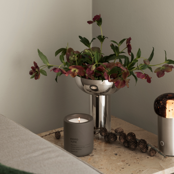 Stylish tabletop arrangement with a floral centerpiece and a lit scented candle.