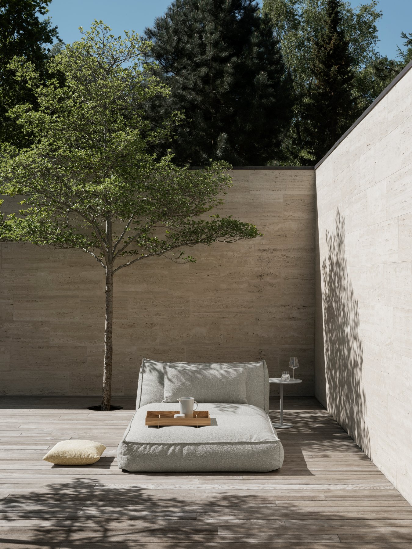 Serene outdoor seating area with a tree, neutral tones, and minimalist design.