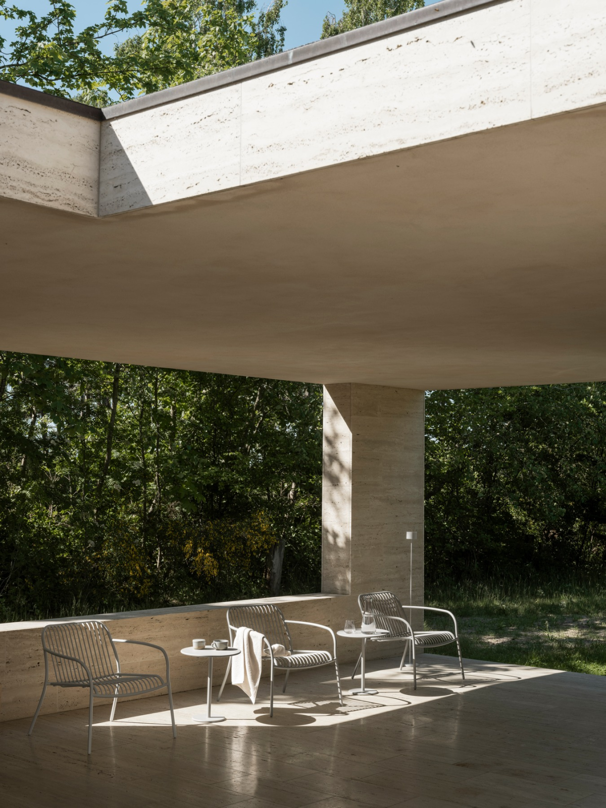 Moderne Terrasse mit minimalistischen Stühlen und Blick auf die Natur.